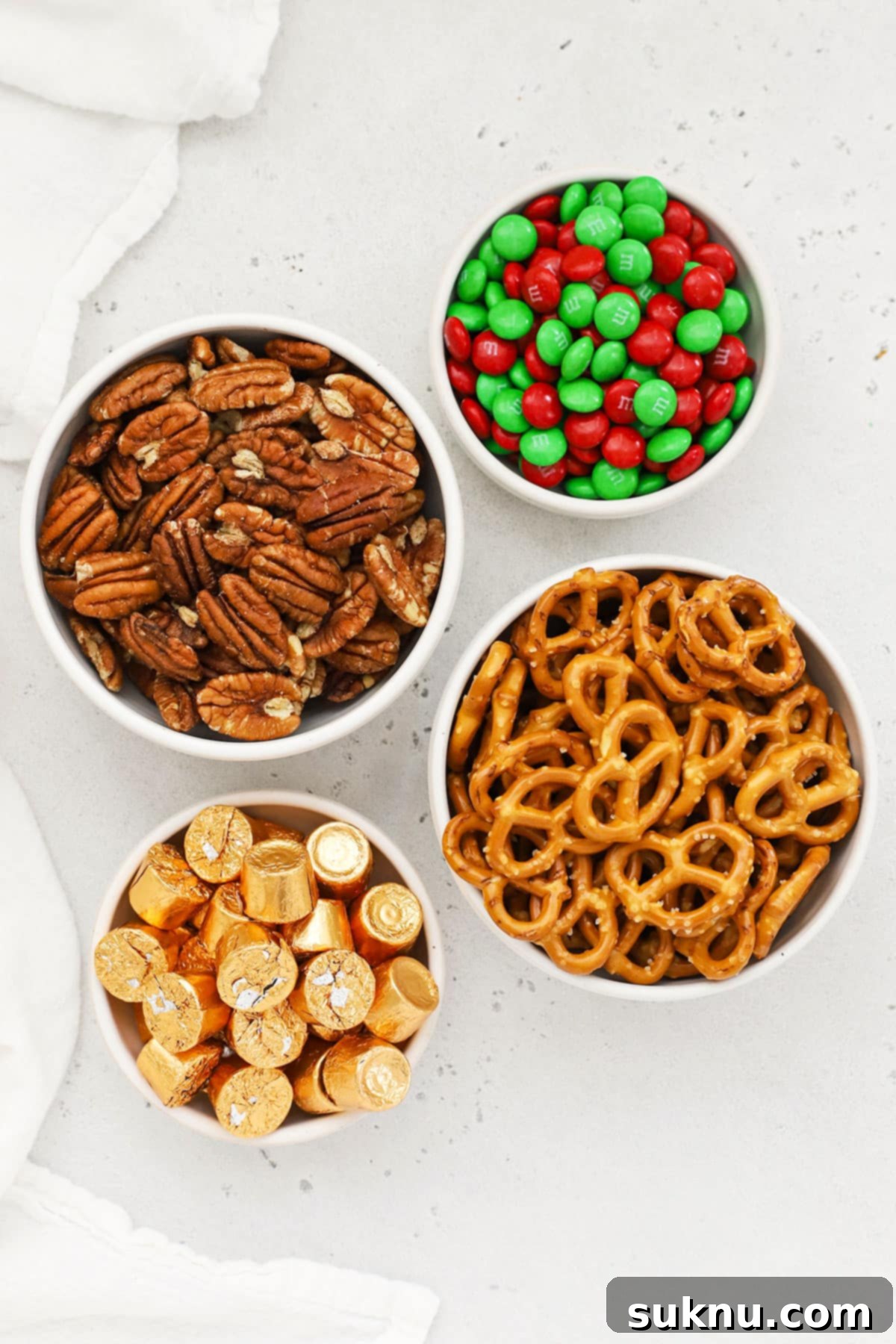 Gluten-Free Rolo Pretzel Turtles 3 Essential ingredients laid out for crafting gluten-free Rolo pretzels, including M&M's and pecans.