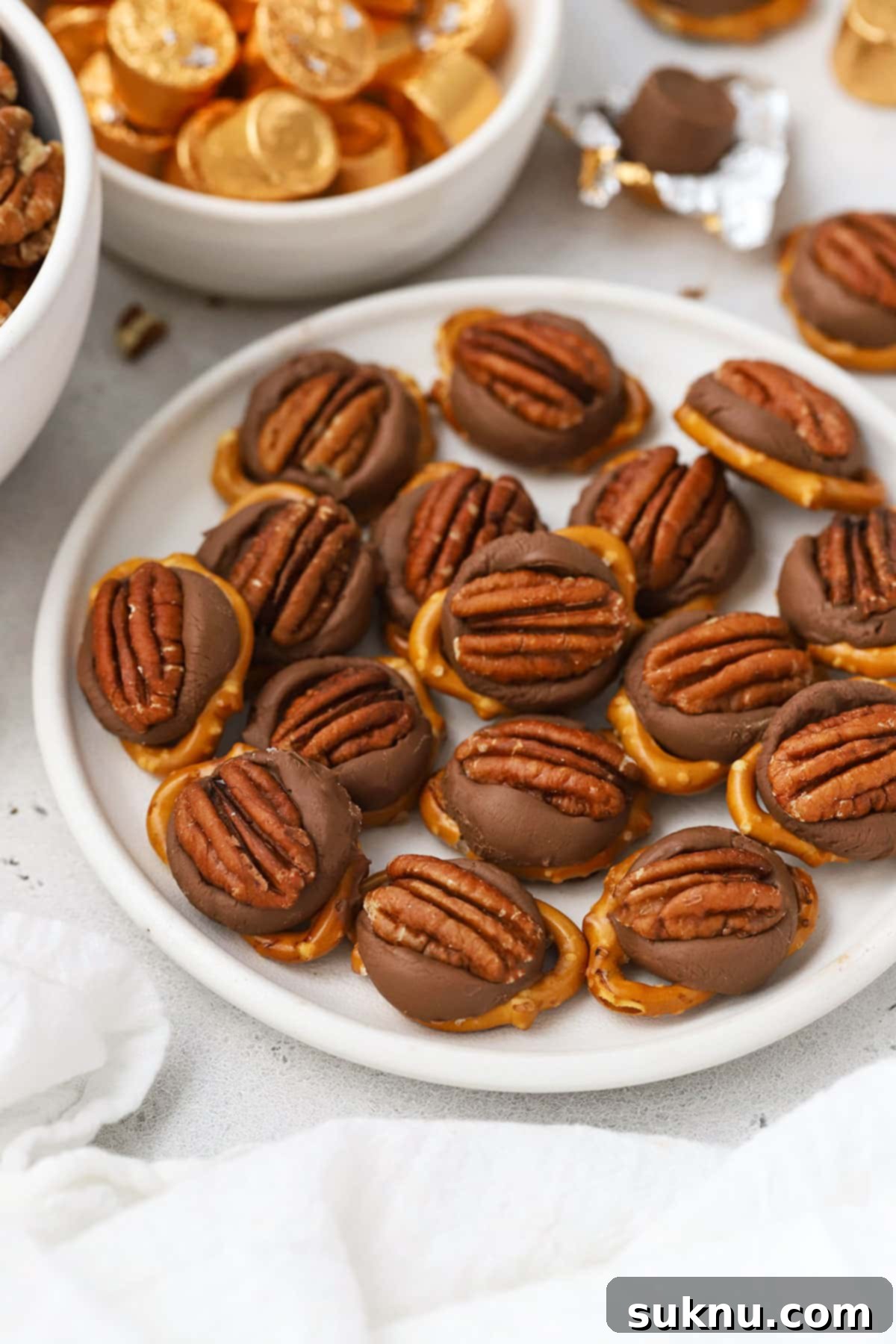 Gluten-Free Rolo Pretzel Turtles 6 A pristine white plate holds a delightful arrangement of gluten-free Rolo pretzel turtles, showcasing their elegant presentation.