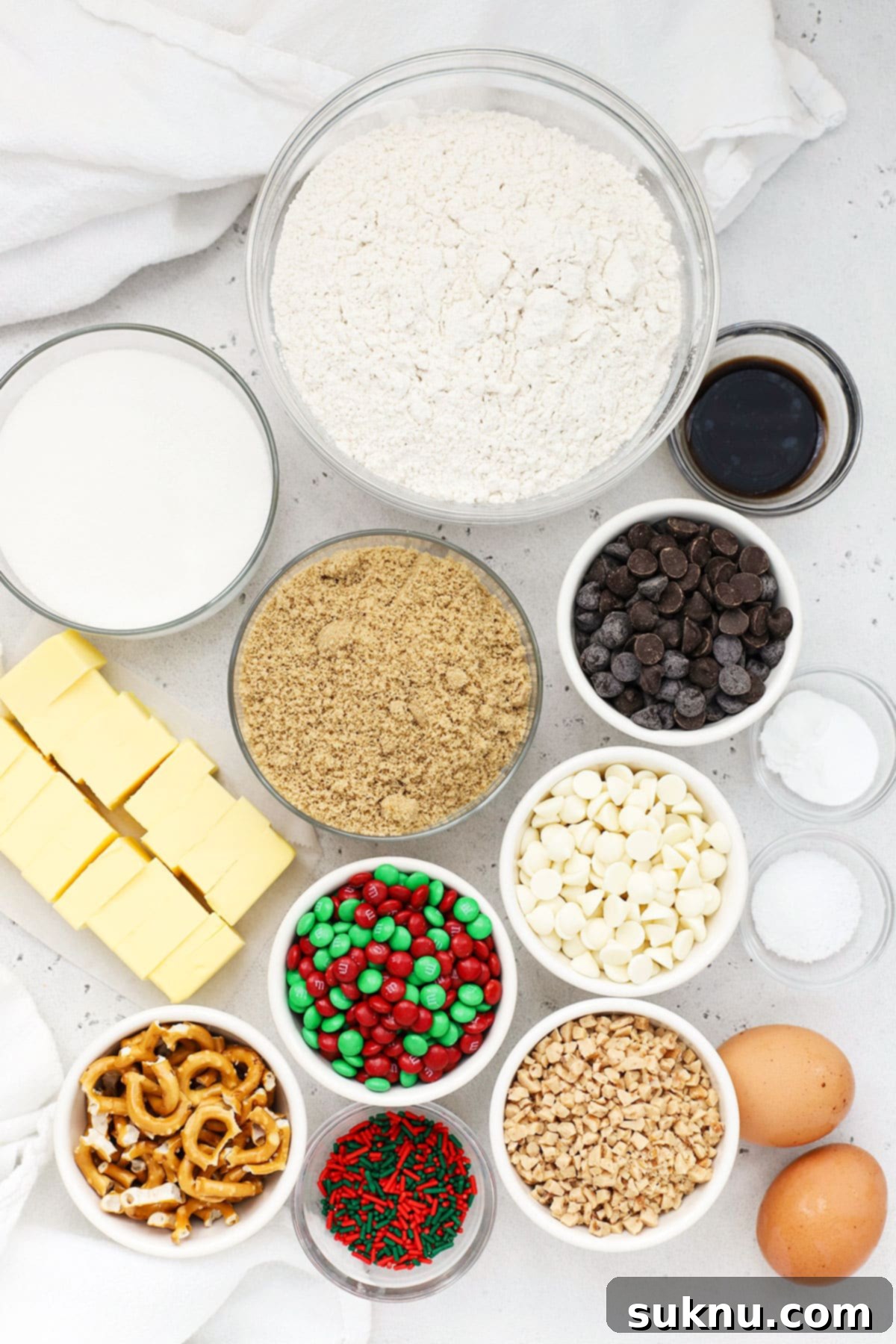 Assortment of ingredients for gluten-free Christmas kitchen sink cookies, including flour, sugars, butter, eggs, and various mix-ins