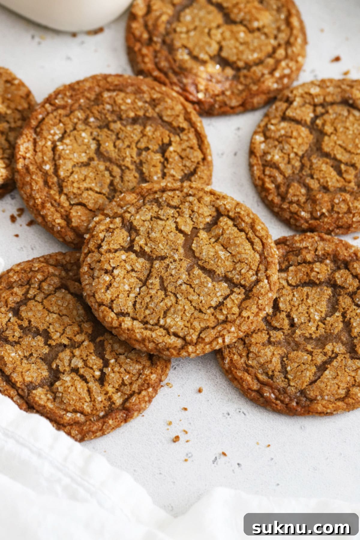 Stacked gluten-free molasses cookies next to a bottle of milk, ready to be enjoyed.
