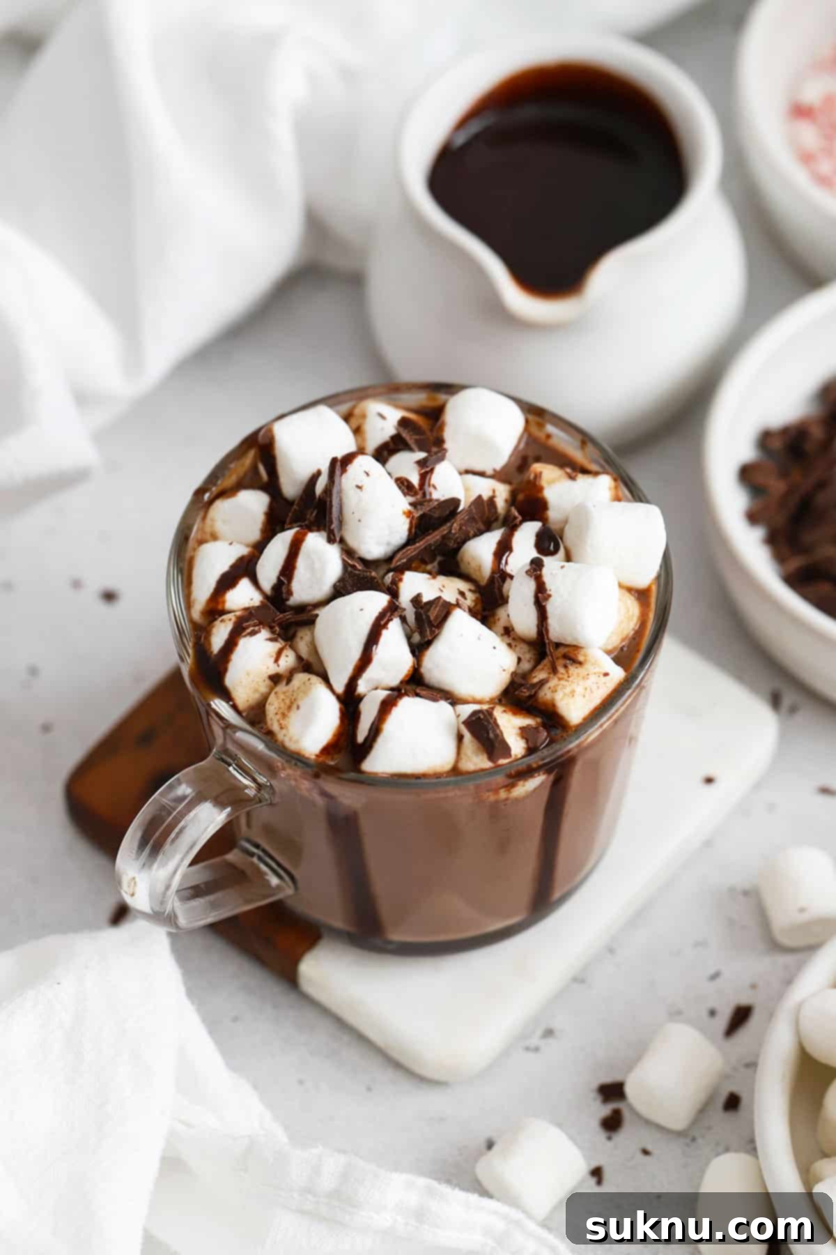homemade hot chocolate topped with marshmallows and chocolate syrup