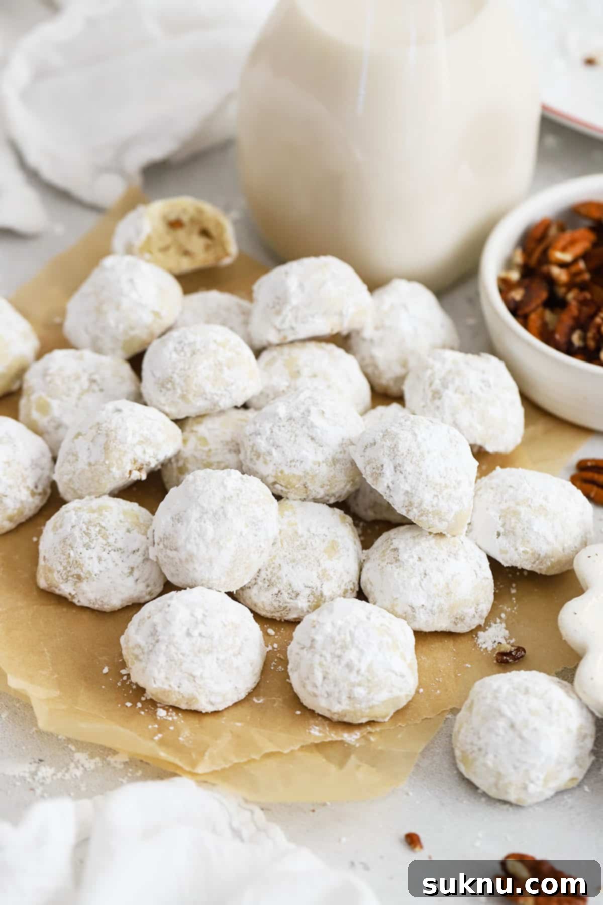 Gluten-Free Snowball Cookies 3 gluten-free snowball cookies on a brown sheet of parchment paper