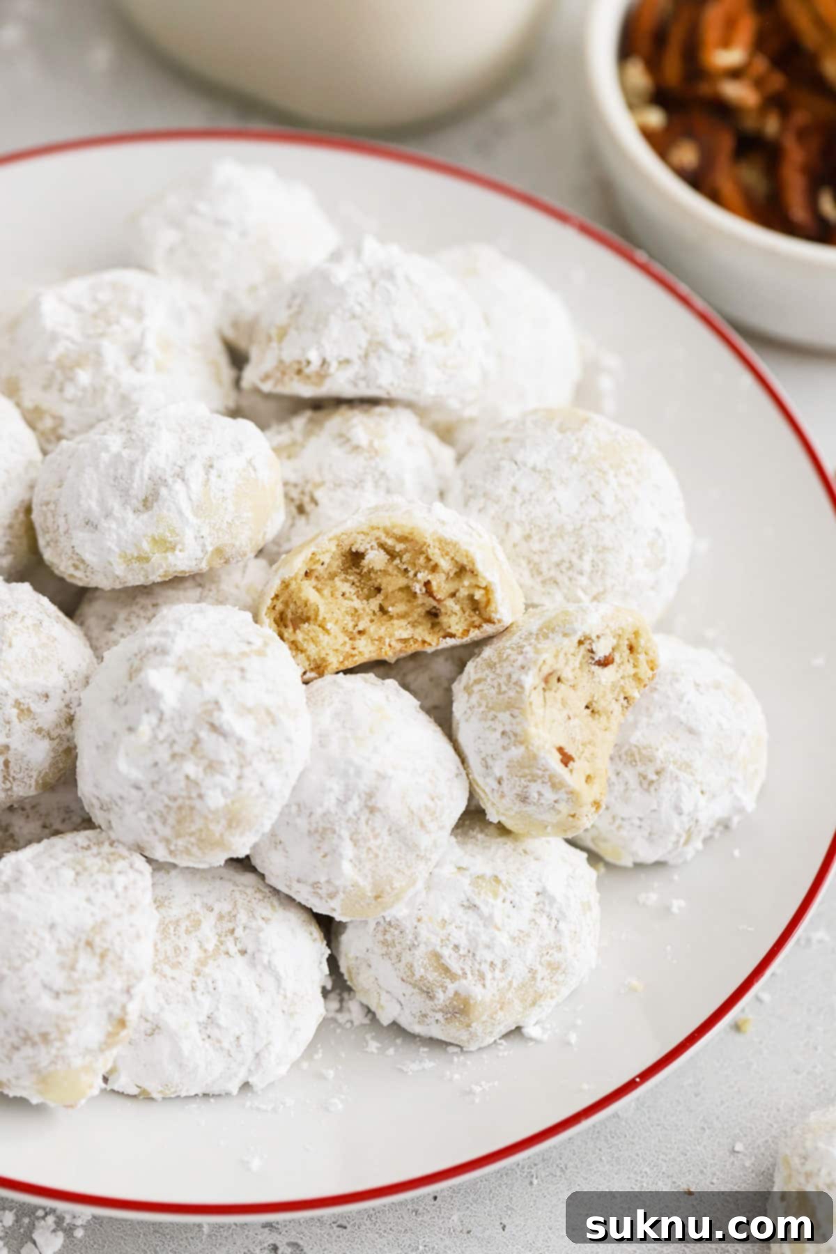 Gluten-Free Snowball Cookies 7 gluten-free mexican wedding cookies on a red rimmed white plate