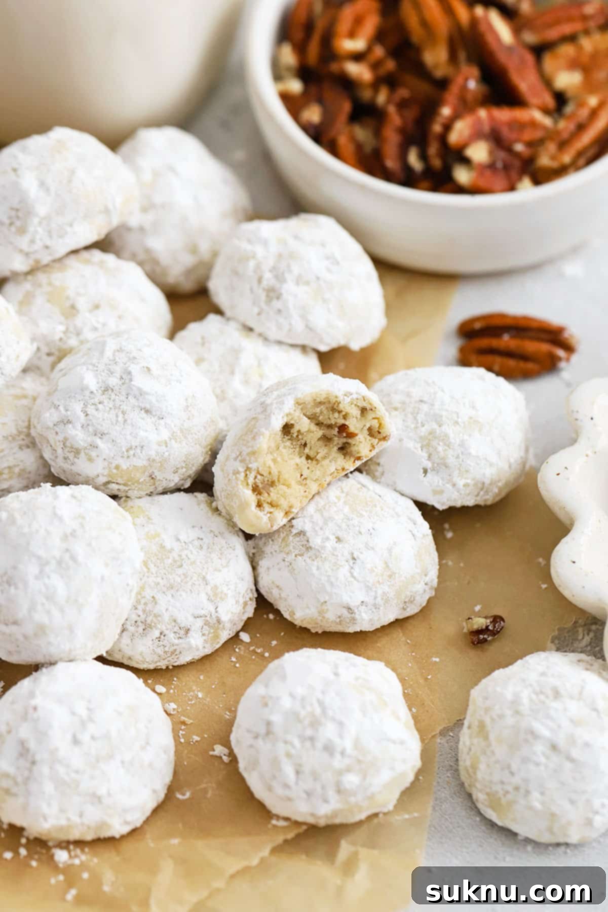 Gluten-Free Snowball Cookies 8 gluten-free snowball cookies on a brown sheet of parchment paper