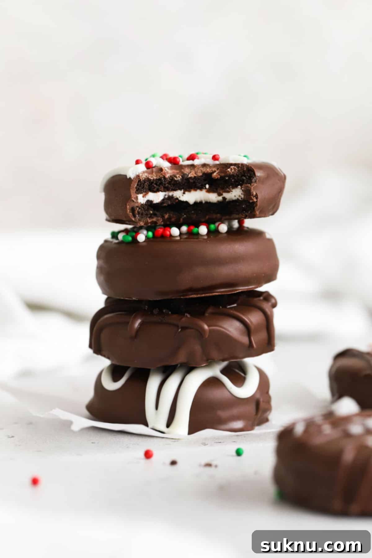 No-Bake Chocolate Dipped Oreos 7 Perfectly stacked gluten-free chocolate covered Oreos with a variety of festive decorations on a clean white background.