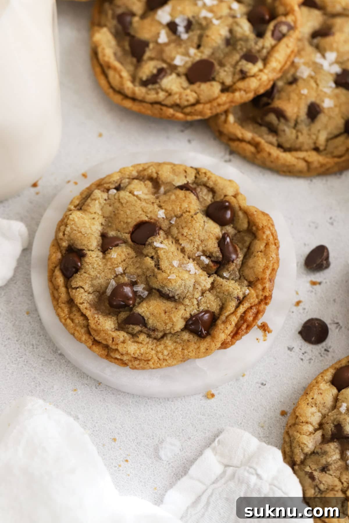 Close-up of golden-edged gluten-free chocolate chip cookies cooling on a rack, showcasing their perfect texture.