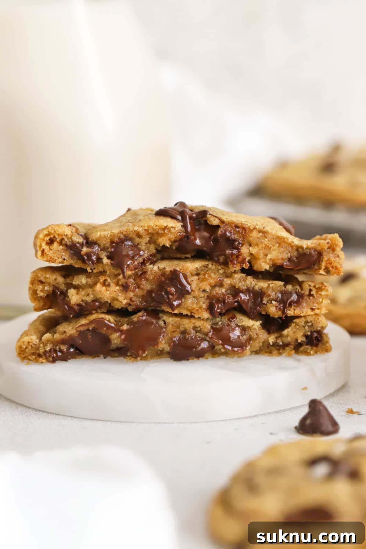 A stack of perfectly baked gluten-free chocolate chip cookies next to a bottle of milk, ready to be enjoyed.