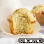 a gluten-free almond poppy seed muffin with a bite taken out of it to show the fluffy texture