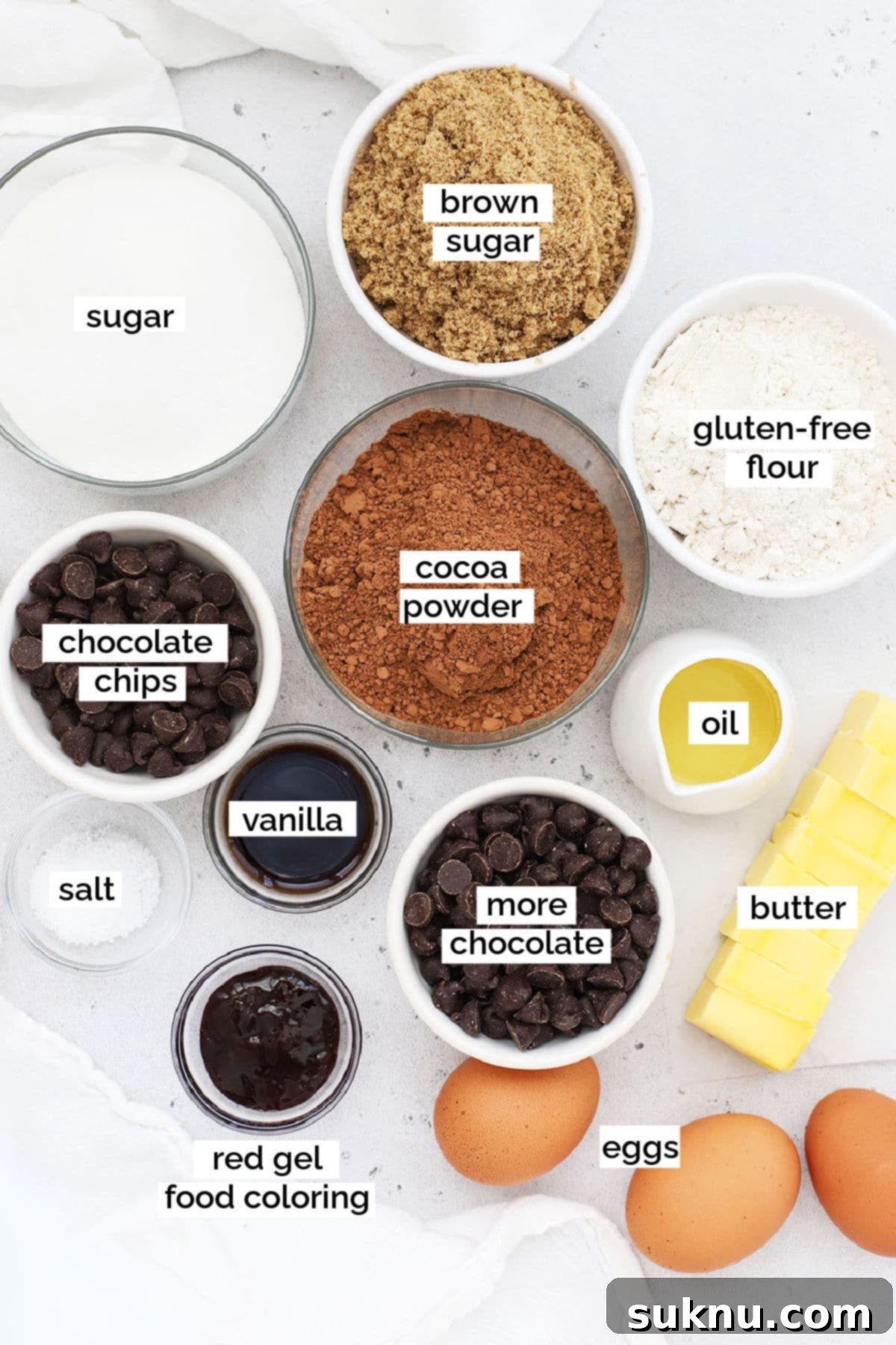 Assorted ingredients for gluten-free red velvet brownies laid out on a kitchen counter, ready for baking.
