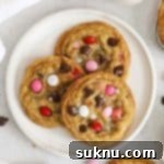 Three gluten-free Valentine's cookies with m&ms on a white plate