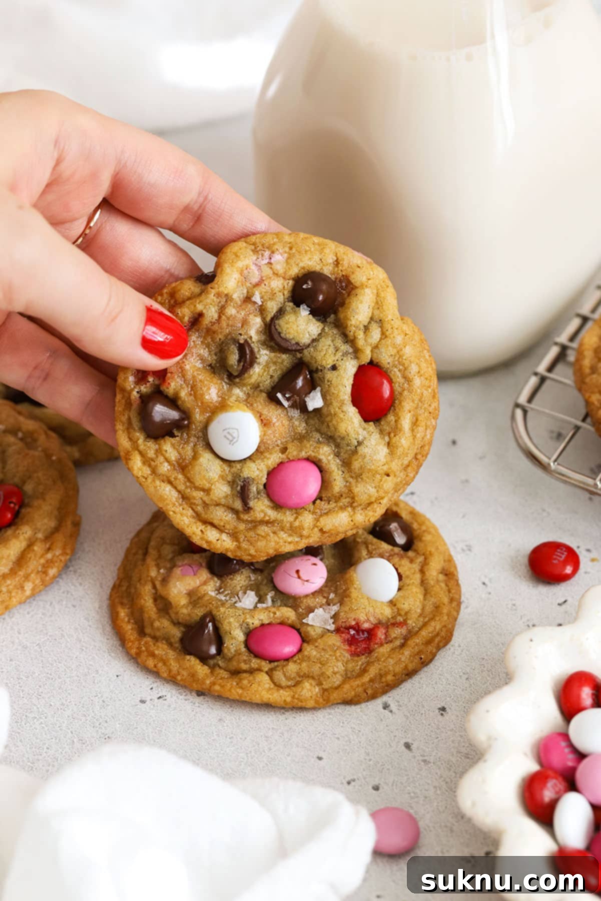 stacking gluten-free Valentine's Day cookies with a bottle of milk in the background
