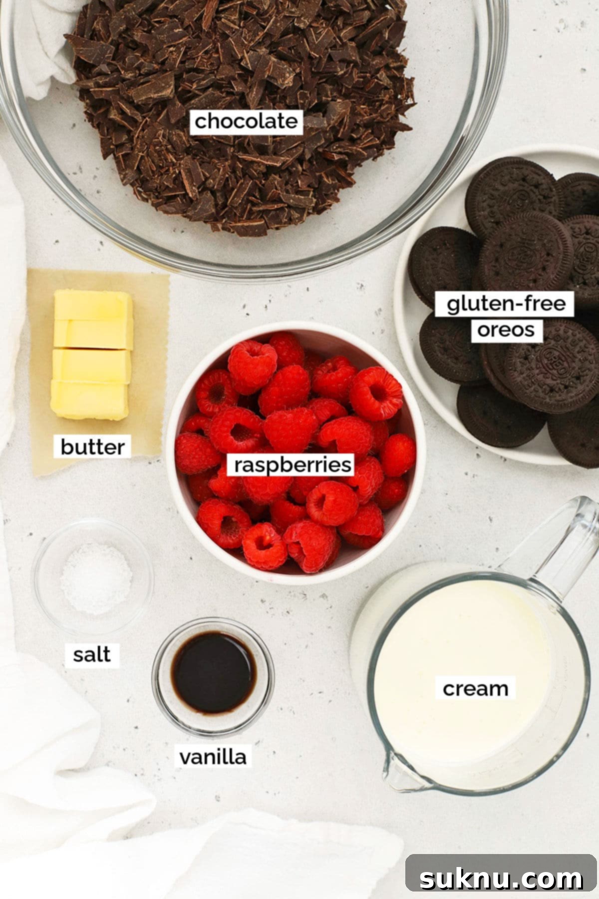 A selection of fresh ingredients laid out for making a gluten-free chocolate tart, including gluten-free Oreos, chocolate, butter, and heavy cream.