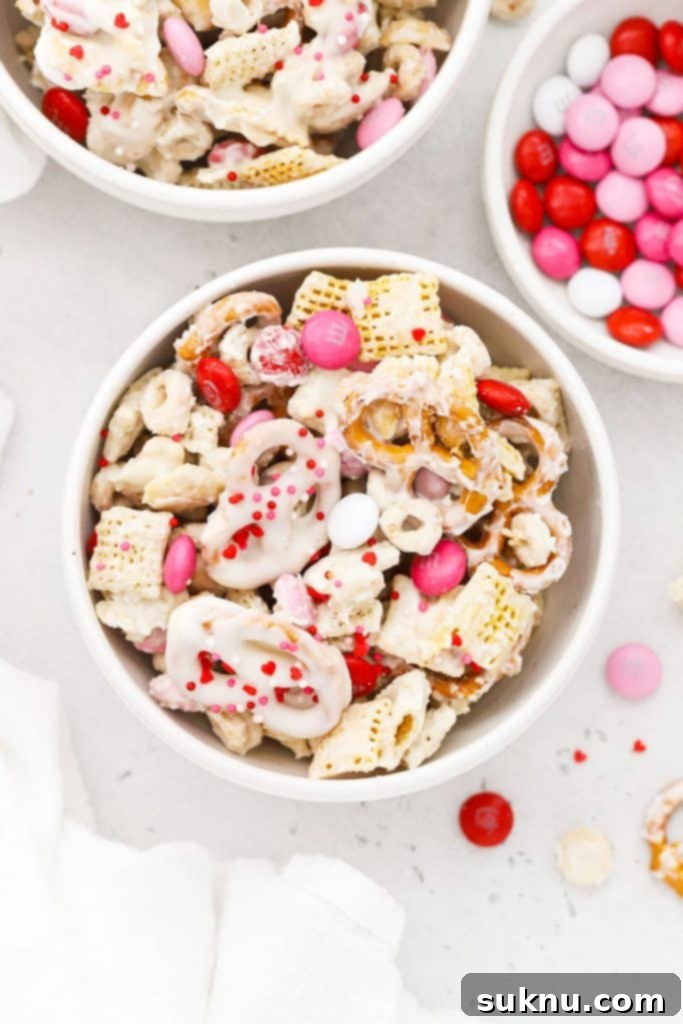 Gluten-free Valentines Chex Mix with red, white, and pink m&ms in a white bowl, perfect for a festive treat.