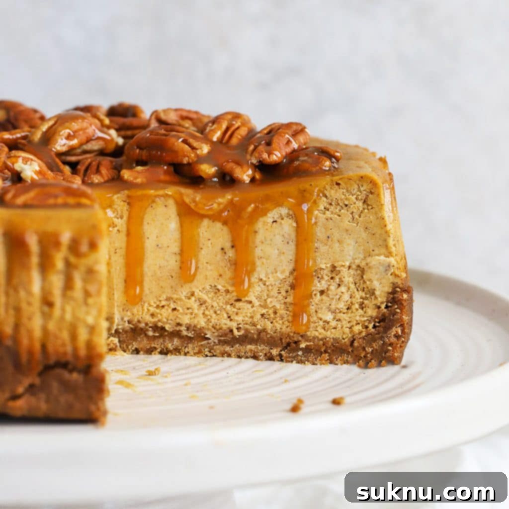 A front view of a luscious gluten-free pumpkin cheesecake, perfectly spiced and topped with a creamy garnish.