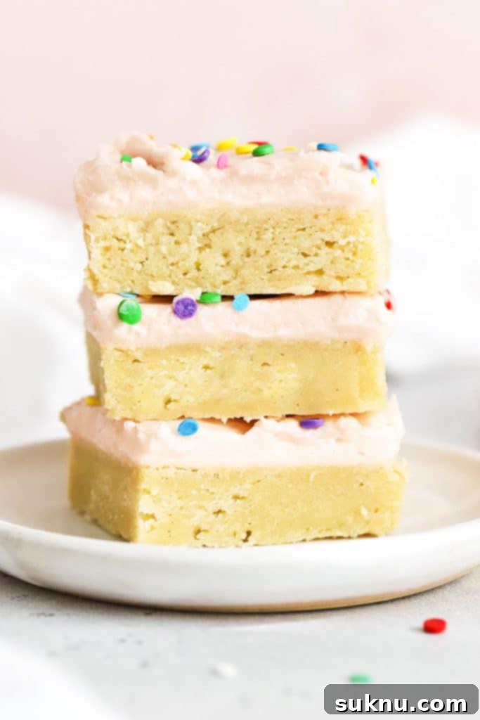 Soft Cream Cheese in Minutes 10 Three sugar cookie bars with pink frosting, perfectly soft and stacked on a white plate