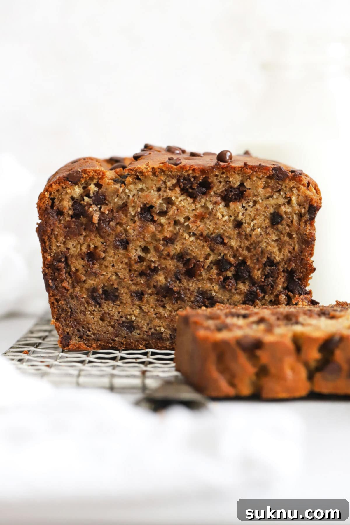 A freshly sliced loaf of moist gluten-free chocolate chip banana bread, revealing its soft texture and generous chocolate chips.