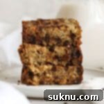 Three slices of gluten-free chocolate chip banana bread stacked on a white plate, showcasing a close-up of the crumb and melted chocolate chips.